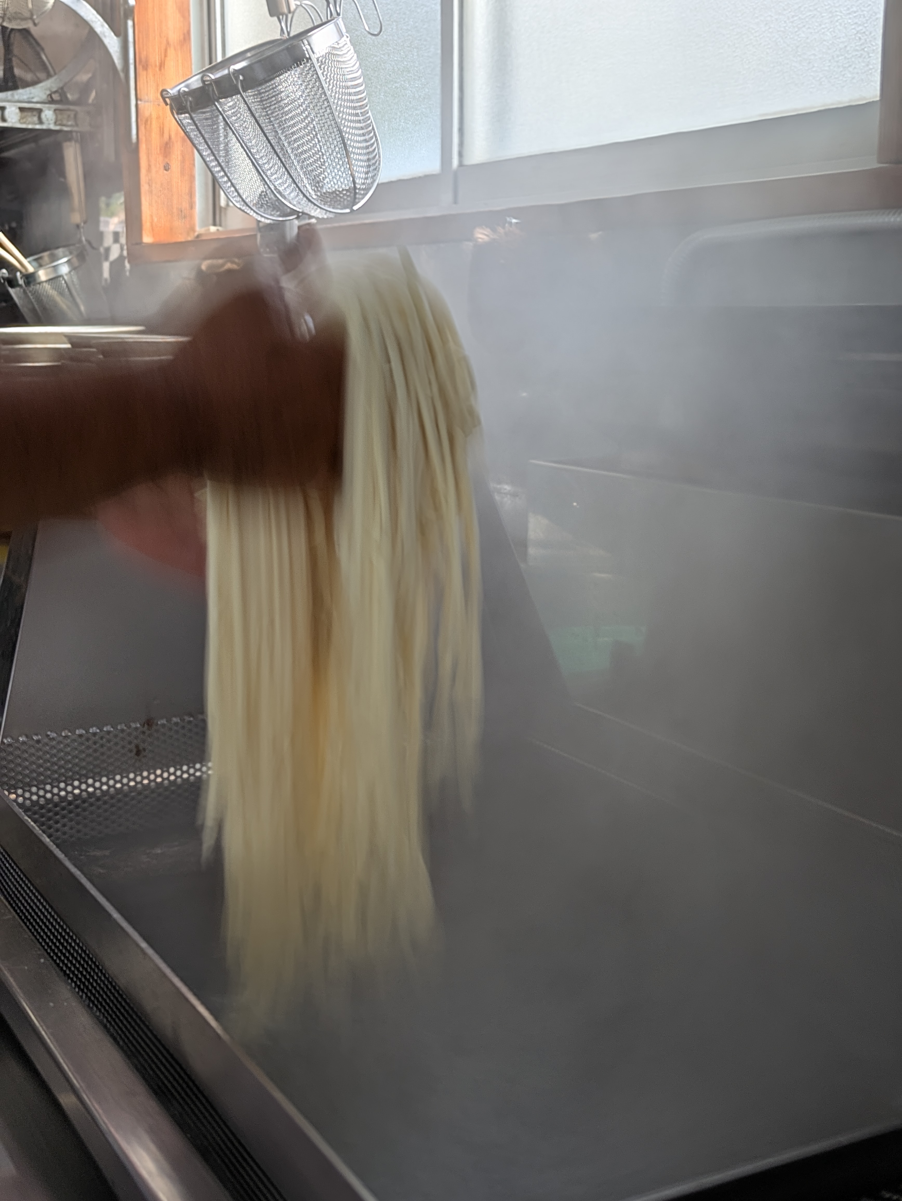 手でうどんを伸ばす